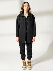 Full-length front view of the Maru black shirt jacket showing its relaxed longline fit, button front and collar.