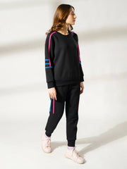 Side profile of the Michi Black fleece matching set, highlighting its sporty silhouette and contrast sleeve tape.
