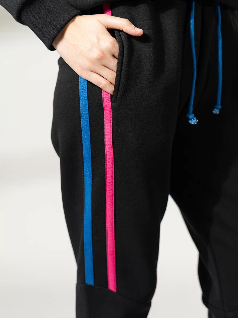 Close-up of Michi Black matching trousers showing the drawstring waistband and colourful side stripe detailing.