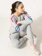Model wearing the Michi Heather Grey athletic-inspired matching set in a seated pose, showing the relaxed fit and striped sleeves.