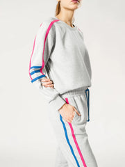 Side view of the Michi Heather Grey sweatshirt and trouser set highlighting the pink and blue side stripe detailing.