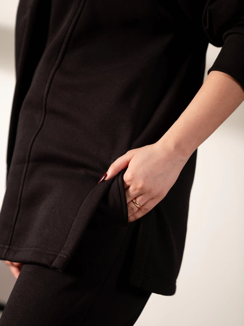 Close-up of the Nina Black sweatshirt showing the side pocket area, soft fabric and hem detailing