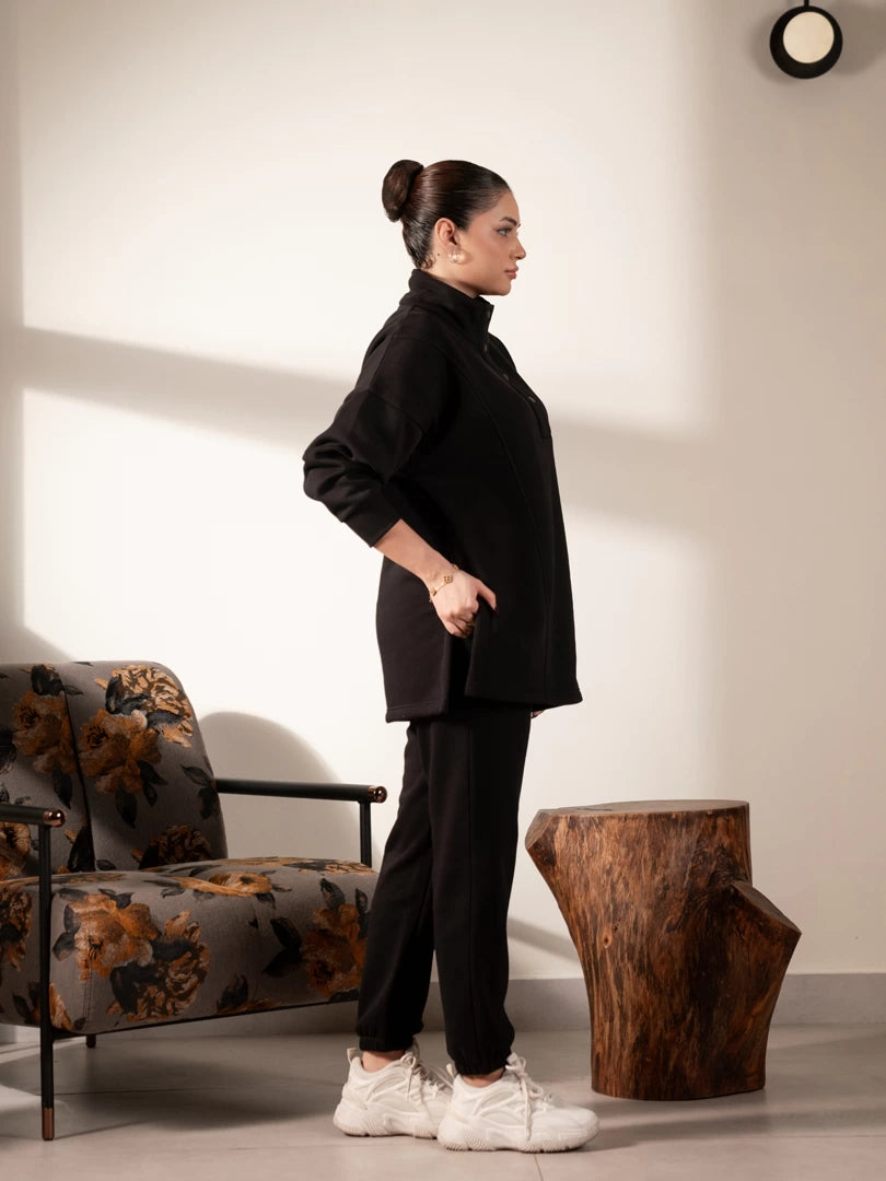 Side view of the Nina Black matching set showing the longer-length sweatshirt and matching black trousers