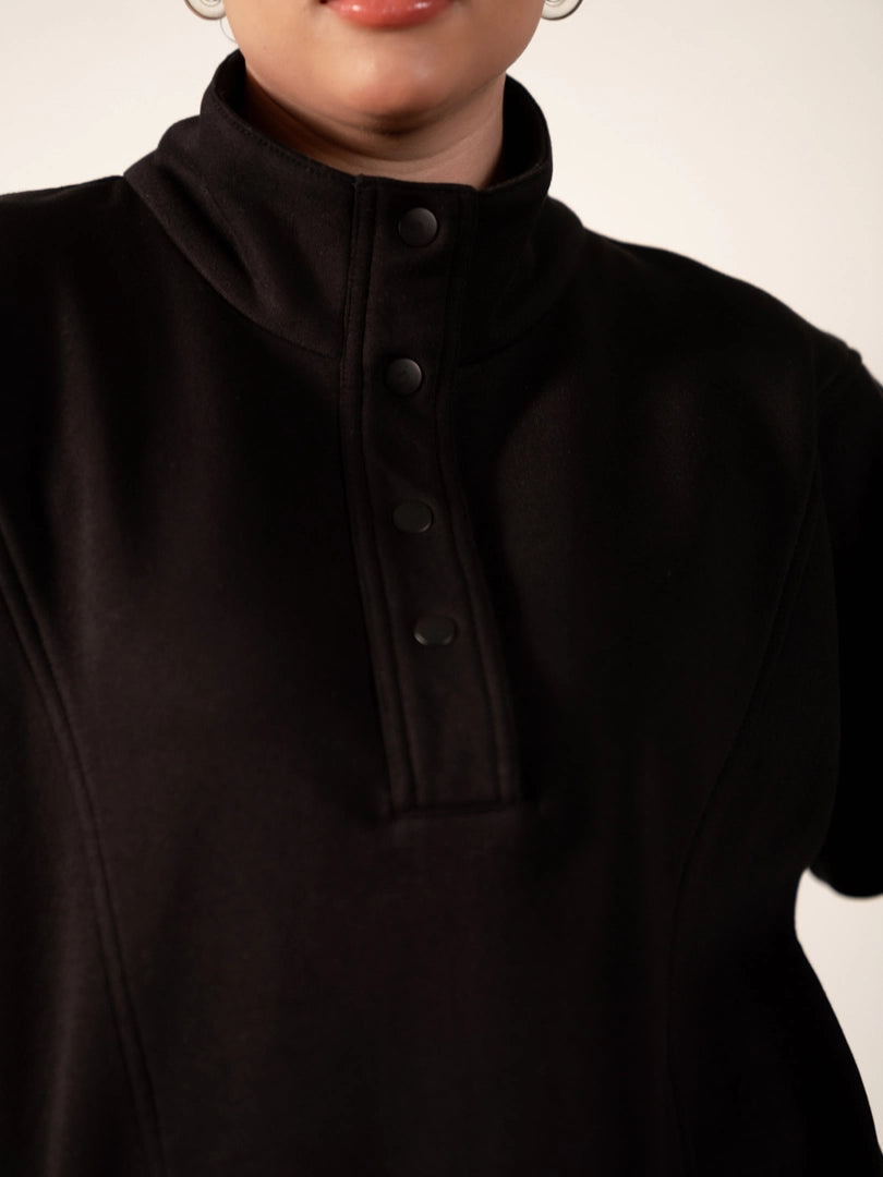 Close-up of the Nina Black fleece sweatshirt showing its stand-neck collar and snap-button closure