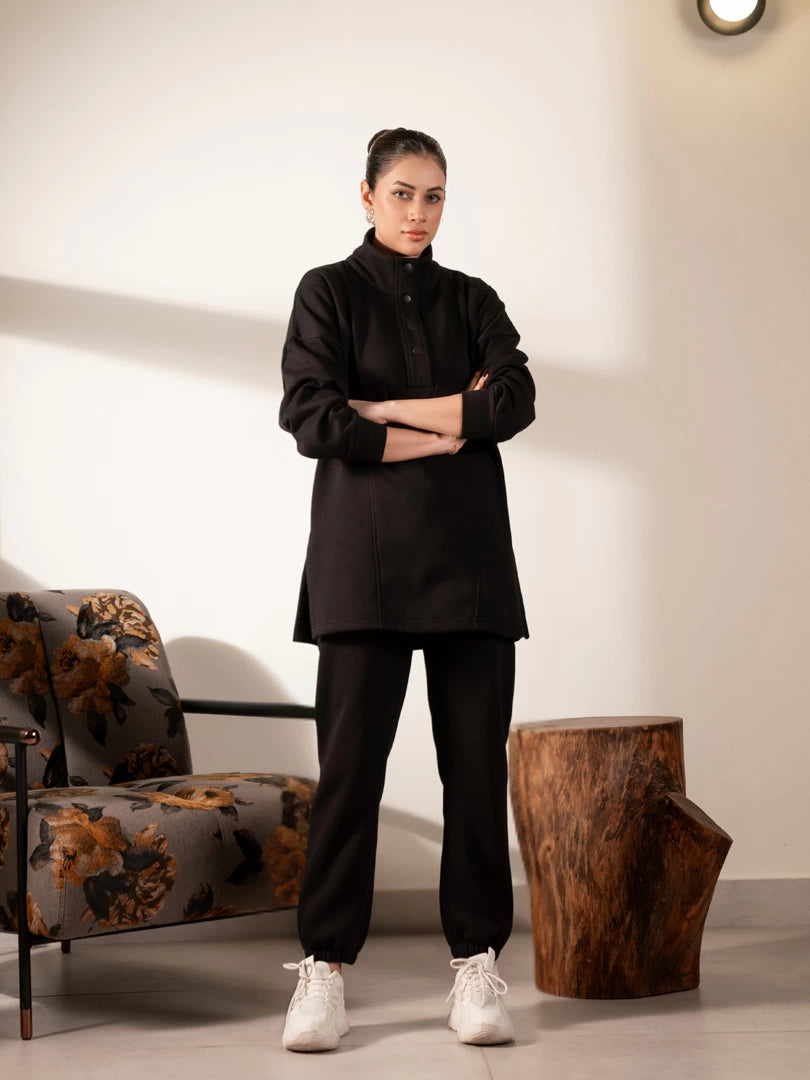 Model wearing the Nina Black winter matching set with a long-length fleece sweatshirt, stand collar and matching trousers