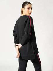 Side and back view of the Ora black top showing its longer back hem over the matching trousers.