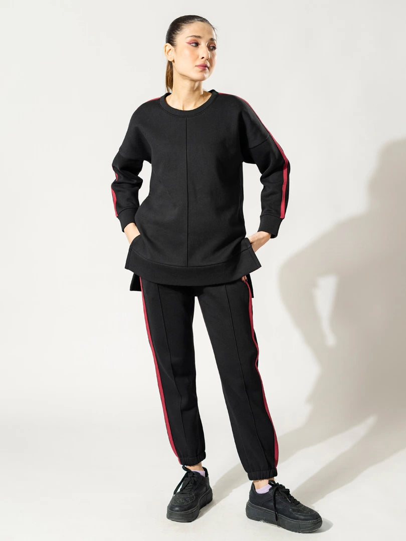 Full-length view of the Ora black two-piece winter matching set, with the model standing with hands on her hips.