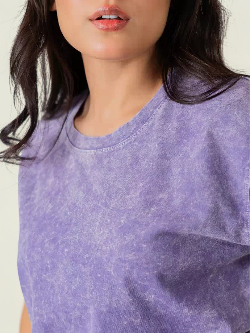 Close-up of the Sage Purple mineral-washed cotton t-shirt highlighting its crew neckline and faded, textured fabric.