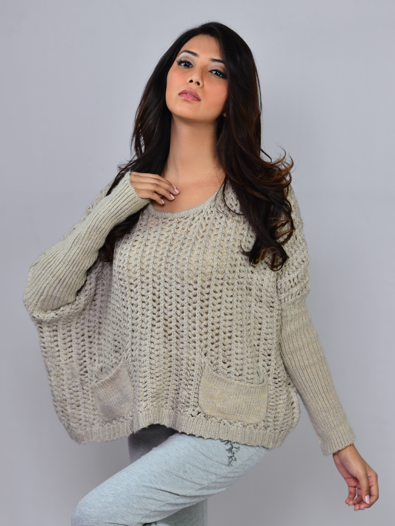 Model standing in a fashion pose wearing Coastline's Sienna Chunky Sweater in Sand, showing its relaxed fit and textured knit design.