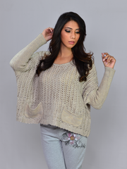 Model posing with raised hands in Coastline's Sand Sienna Chunky Sweater, highlighting the loose sleeves and knit texture.