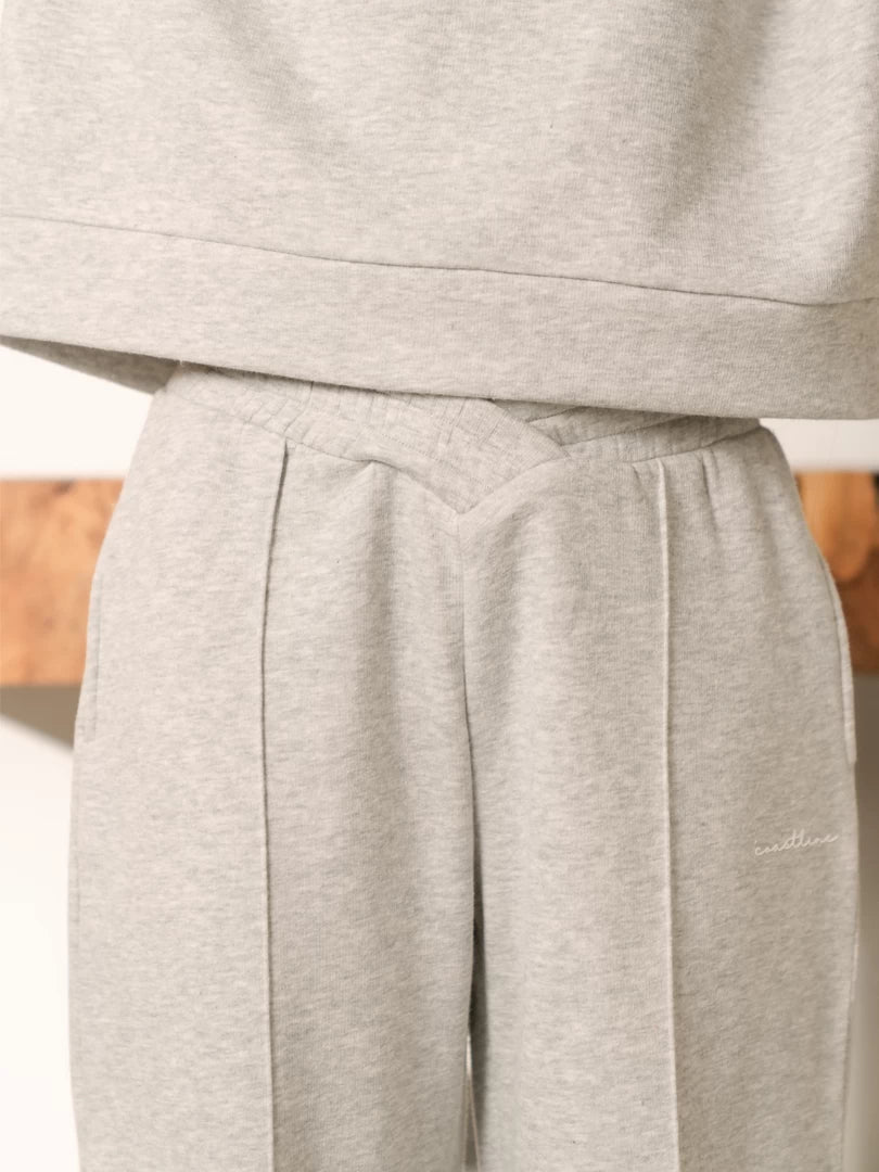 Close-up of the Soho grey sweatpants showing the distinctive waistband and front pleat detail beneath the top hem.