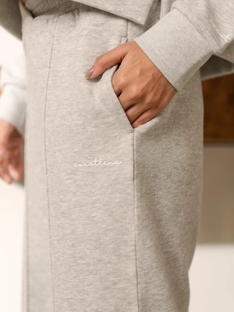 Close-up of the Soho Heather Grey trouser pocket with the model placing one hand inside, showing the heathered fabric.