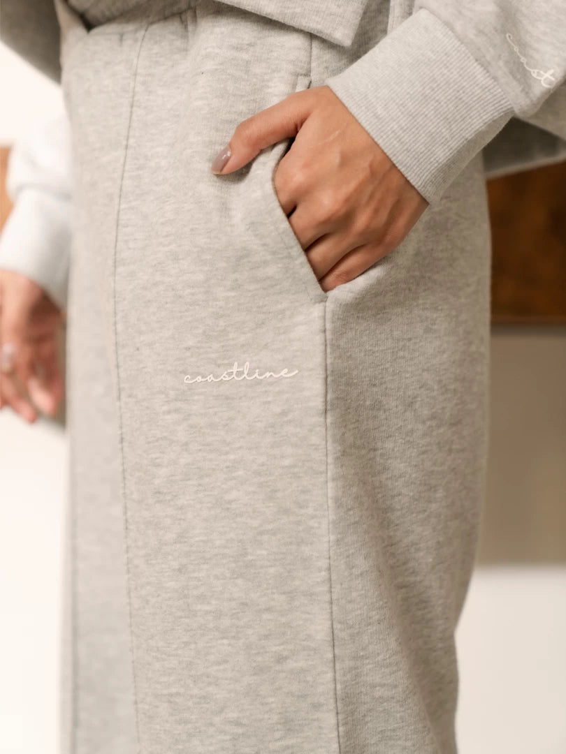 Close-up of the Soho Heather Grey trouser pocket with the model placing one hand inside, showing the heathered fabric.