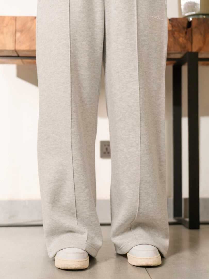 Closer view of the Soho Heather Grey trouser legs showing the wide hems falling over white sneakers.