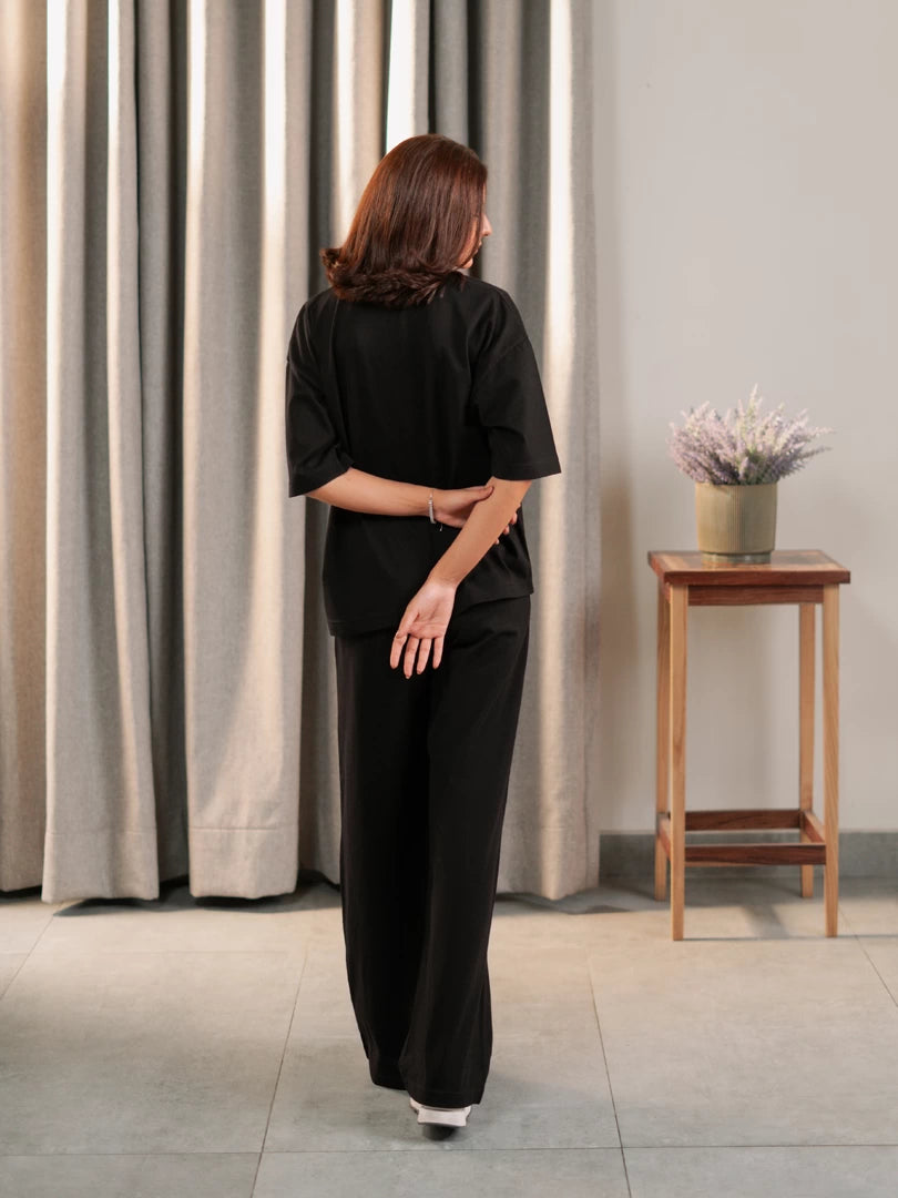 Back view of the Sorelle black oversized co-ord set showing the loose top and matching wide-leg trousers.