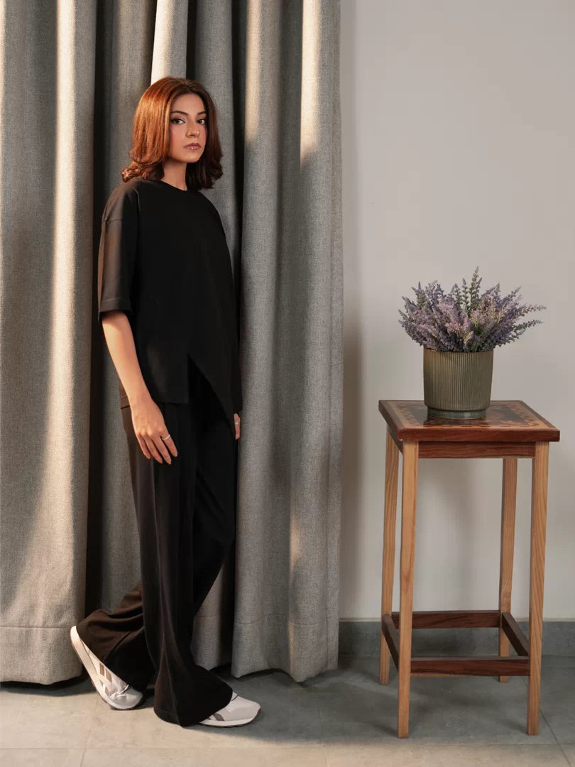 Angled view of the Sorelle black summer co-ord set showing the oversized top and flowing wide-leg trousers.