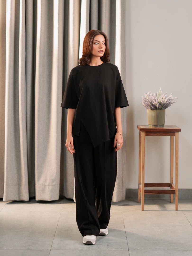 Front view of the Sorelle black two-piece matching set with a drop-shoulder top and pleated wide-leg trousers.