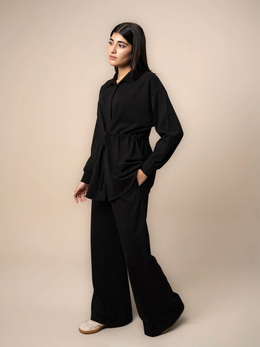Three-quarter view of the Sylvie black matching set with a relaxed button-down shirt and wide-leg trousers.