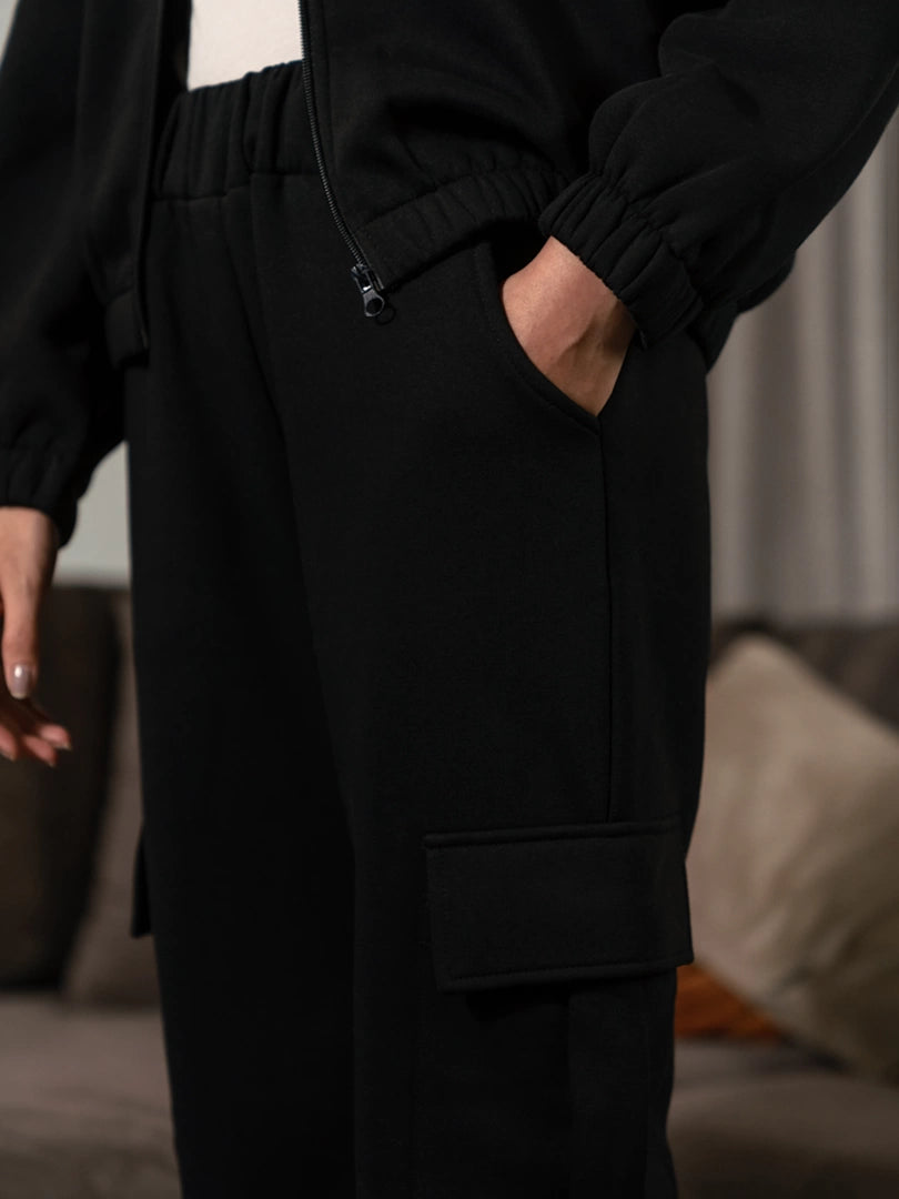 Close-up of the Varley Black matching set showing sleeve and trouser detail