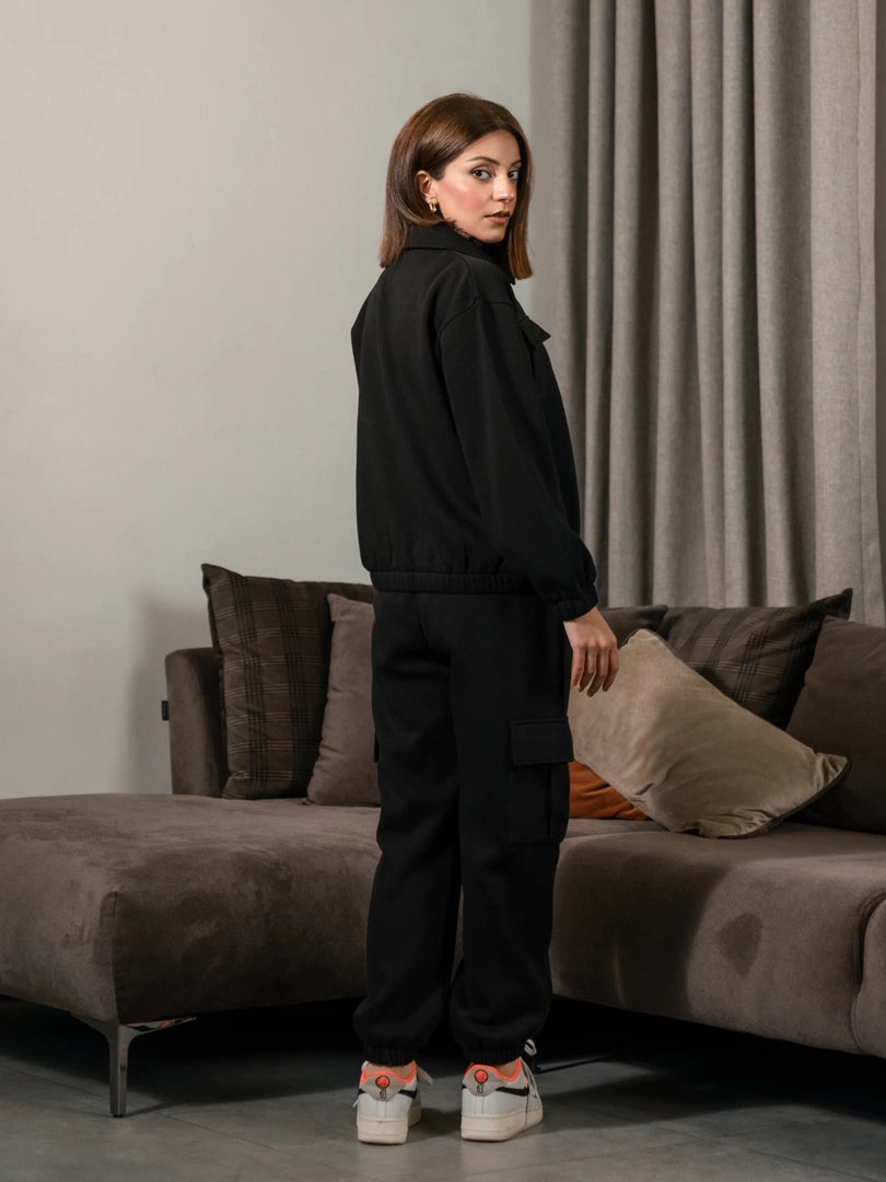 Rear side view of the Varley Black matching set showing the jacket and trouser fit