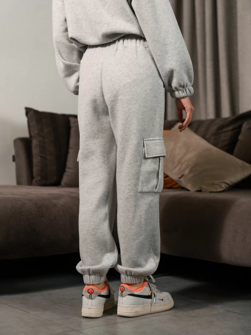 Rear view of the Varley Heather Grey matching set showing the zip-up jacket and relaxed cargo trouser fit