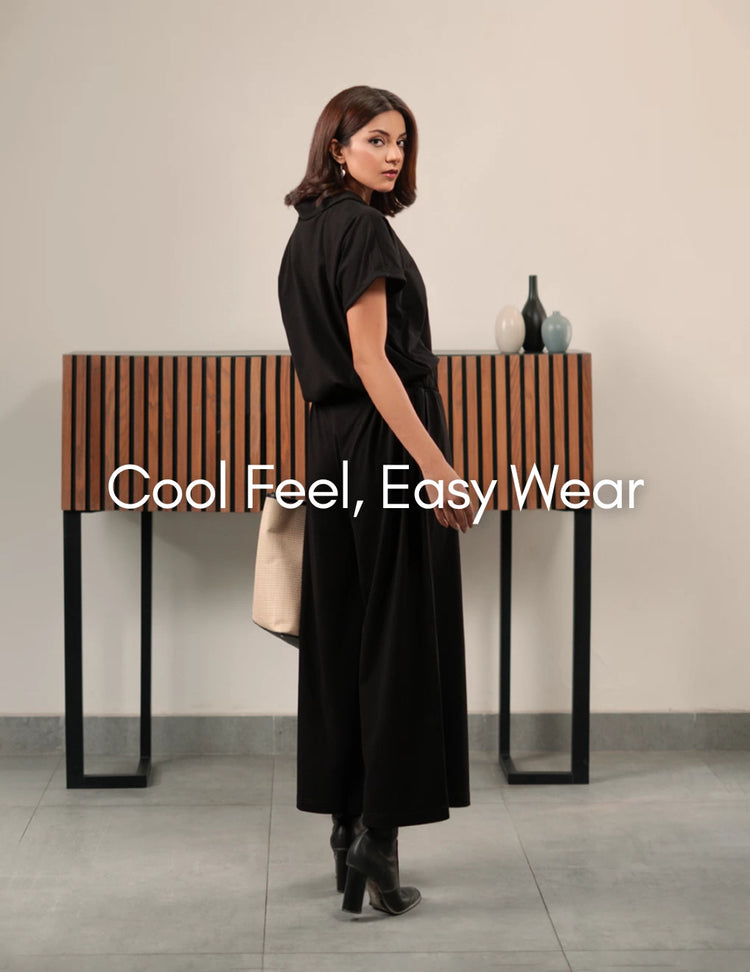 Woman wearing a black dress with ankle boots in Coastline’s “Cool Feel, Easy Wear” banner