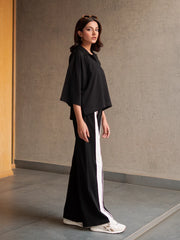 Angled view of the Zane black two-piece matching set with a relaxed collared top and wide-leg trousers.