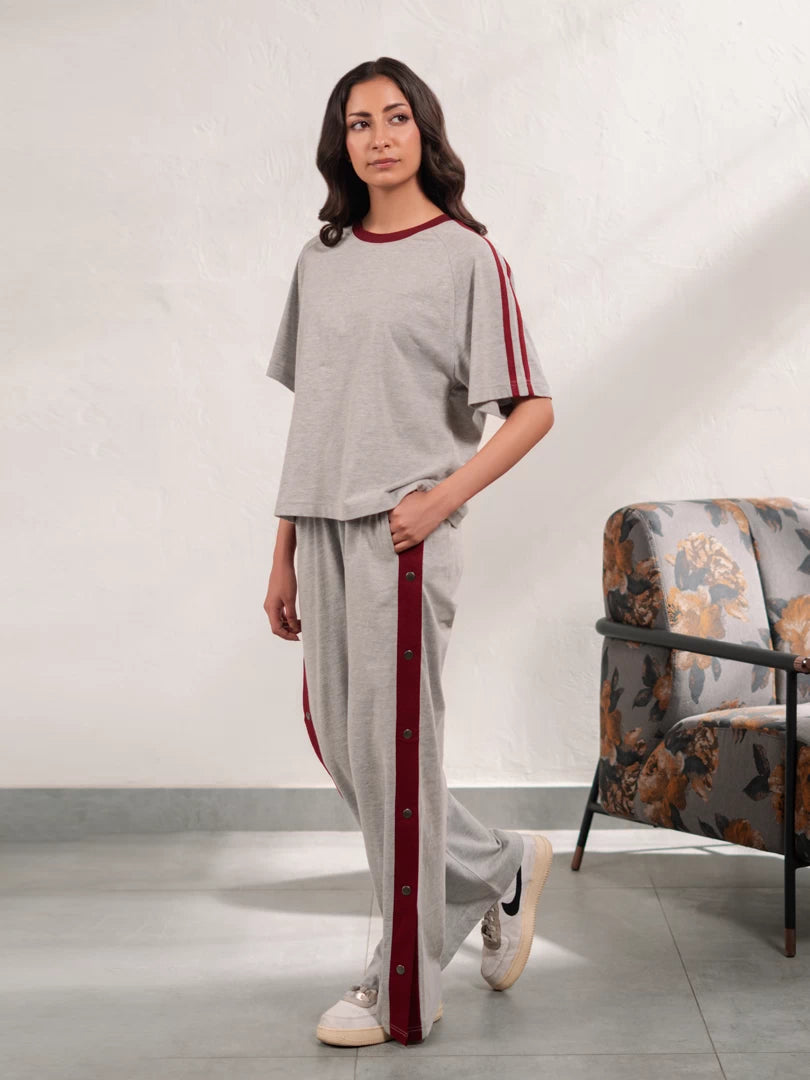 Full-length view of the Zoey Heather Grey matching set showing the relaxed top and wide-leg trousers with contrast side detailing.