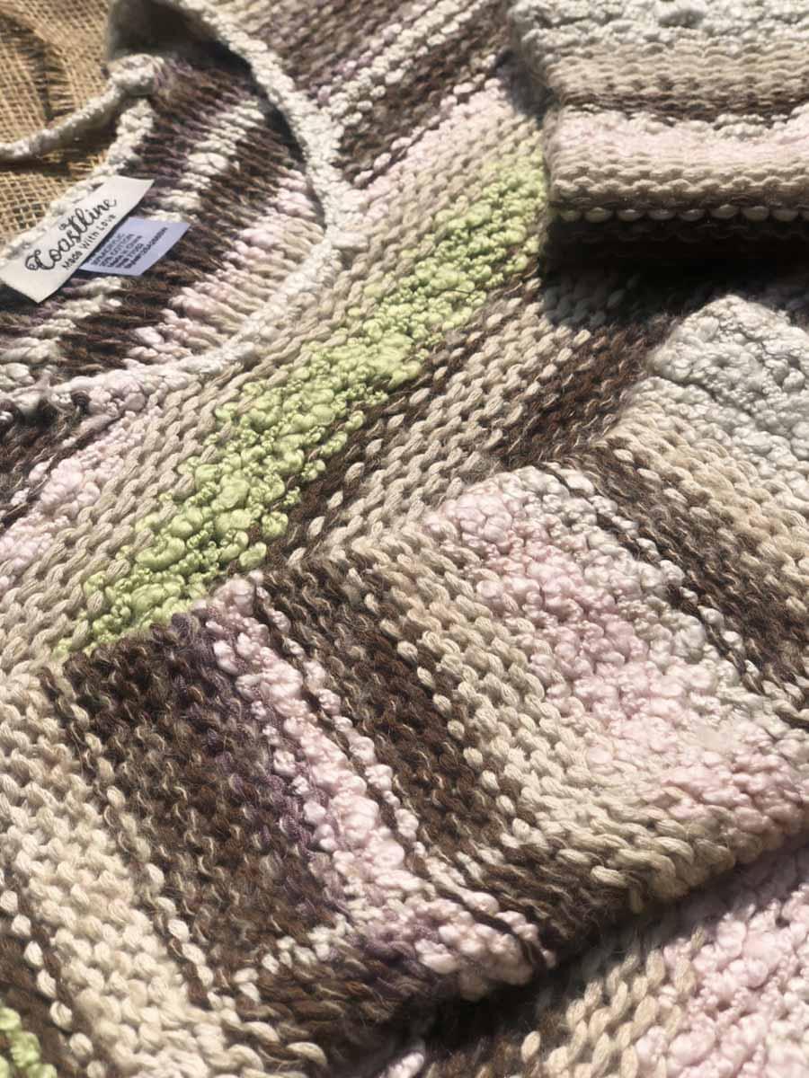 Close-up of the textured multicolor knit fabric and striped pattern of Coastline's Cropped Multicolor Sweater.