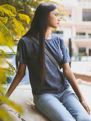 Model wearing Coastline's Heritage Fashion Tee in Pixel Blue, seated outdoors and showing the textured finish and relaxed short sleeves.