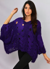 Model posing with one arm raised in Coastline's Oversize Audrey Sweater in Purple Indigo, showing its wide sleeves and loose fit.